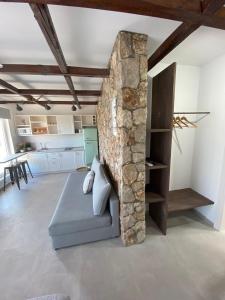 a living room with a couch and a stone wall at Oliva in Faliraki