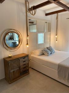 una camera da letto con un letto con specchio e un comò di Oliva a Faliraki