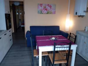 un soggiorno con tavolo e divano blu di Appartamento Flora a Tremosine Sul Garda