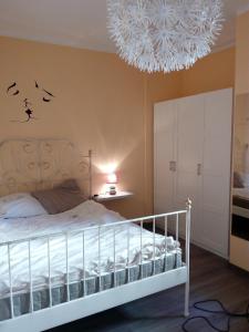 a bedroom with a white bed and a chandelier at Appartamento Flora in Tremosine Sul Garda