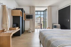 a hotel room with a bed and a tv at Castel Beau Site in Perros-Guirec