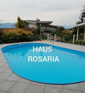 a swimming pool with a sign that reads has rosania at Haus Rosaria in Stallhofen