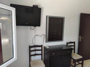 Habitación con escritorio y TV en la pared. en Villa Vera, en Sivota