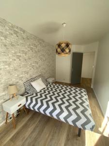 - une chambre avec un lit et un mur en briques dans l'établissement Le Travel, à Acigné