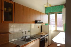 een keuken met een wastafel en een koelkast bij Cimarosa 5 in Follonica