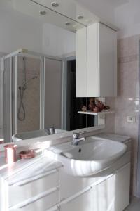 een witte badkamer met een wastafel en een bad bij Cimarosa 5 in Follonica