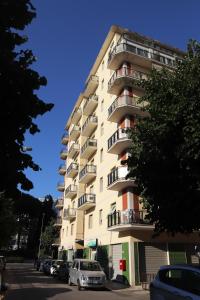 een hoog gebouw met auto's geparkeerd voor het bij Cimarosa 5 in Follonica