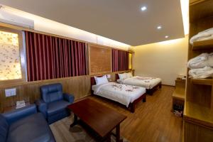 A bed or beds in a room at UCT Taunggyi Hotel