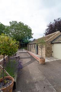 une rangée de bâtiments en briques avec des arbres et des plantes dans l'établissement MJPatTheShepherds, à Cambridge