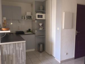 una cucina con bancone e forno a microonde di Les Balcons de la Mer a Valras-Plage Altre 18 foto