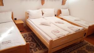two beds in a room with white sheets and pillows at Hazanéző Panzió in Corund