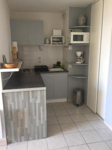 a kitchen with white cabinets and white appliances at Les Balcons de la Mer in Valras-Plage