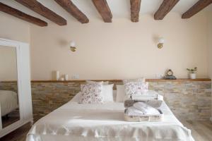 a bedroom with a white bed with a brick wall at Casa Rural El Morral in La Mata de los Olmos +27 photos