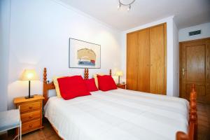 a bedroom with a large white bed with red pillows at Poseidon Denia in Denia +15 photos