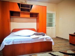 a bedroom with a bed with a wooden headboard at Casa Petrescu in Curtea de Argeş
