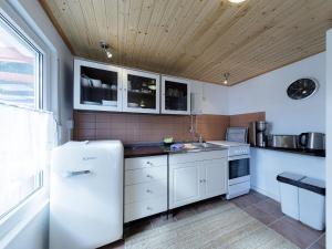 cocina con electrodomésticos blancos y techo de madera en Seegefluester am Malchower See en Malchow