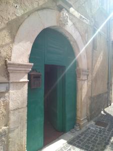 an archway in a building with a green door at villagiannina in Teggiano