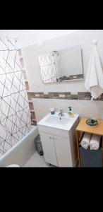 法魯的住宿－Reis Turismo，浴室配有盥洗盆、镜子和浴缸