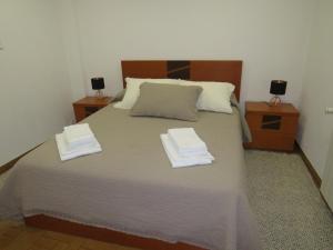 um quarto com uma cama grande com duas toalhas em Casa Porta de Santiago em Pinhel