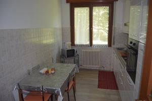 布斯托阿西齊奧的住宿－Al Salice tranquillità nel verde Via Amendola 24，一间带桌子和微波炉的小厨房