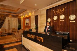 Golden Inn Hotel في القاهرة: رجل يقف على منصة في بهو الفندق