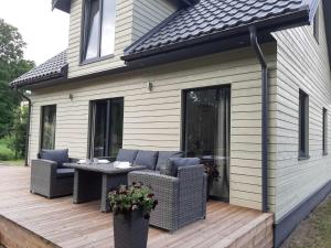 a patio with a table and chairs on a deck at Mazoji vila in Birštonas +9 photos