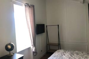 a bedroom with a bed and a mirror and a window at Studio sous les toits in Lyon