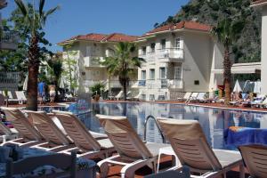 a row of lounge chairs next to a swimming pool at The Blue Lagoon Deluxe Hotel in Oludeniz