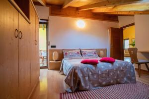 a bedroom with a bed with red pillows on it at B&B Nonno Carlo in Trento