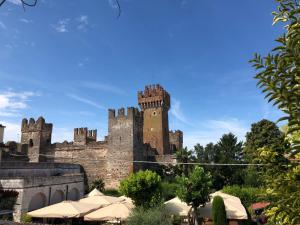 un vieux château avec des tourelles et des tables en face de lui dans l'établissement Castello Centro Storico, à Lazise