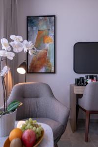 a living room with a chair and a painting at Beach Walk Hotel Jumeirah in Dubai