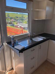 a small kitchen with a sink and a window at Chalet18 in Carmarthen