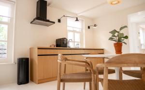 a kitchen with a table and chairs in a room at Nobel Houses & Lofts in Ballum