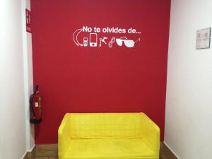 バルセロナにあるブレイク ン ベッドの赤い壁の部屋の黄色いソファ