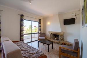 a living room with a couch and a fireplace at Apartamentos Pinto in Quarteira