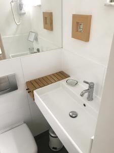 ein weißes Bad mit einem Waschbecken und einem WC in der Unterkunft bel xanto in Köln