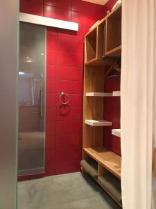 ein Bad mit roten Fliesen und einer Dusche in der Unterkunft bel xanto in Köln