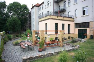 un patio con mesa y bancos frente a un edificio en VacApps Apartments, en Leipzig