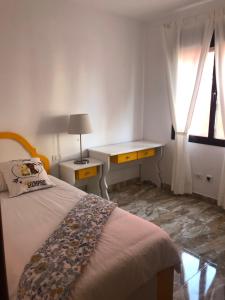 Schlafzimmer mit einem Bett, einem Schreibtisch und einem Fenster in der Unterkunft Lujan 3C entre cielo y mar in Puntallana
