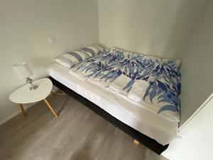 a bed with a blue and white comforter and a table at Cosy studio apartment - perfect for your stay in Rovaniemi! in Rovaniemi