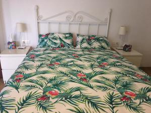 a bed with a white bedspread with flowers on it at The Penthouse in Alora