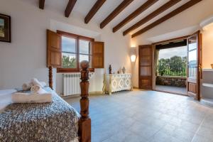 ein Schlafzimmer mit einem Bett und einem großen Fenster in der Unterkunft Villa La Rafal By homevillas360 in Pollença