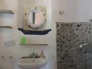 y baño con lavabo, espejo y ducha. en Exclusive apartment in Ecovilla on the beach en Apolakkiá