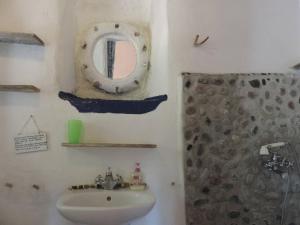 a bathroom with a sink and a mirror and a shower at Exclusive apartment in Ecovilla on the beach in Apolakkiá