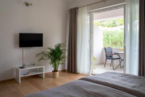 a bedroom with a bed and a tv and a table at Korkyra Fit suites -free gym in Korčula