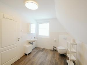 ein weißes Bad mit einem WC und einem Waschbecken in der Unterkunft Ferienwohnungen am Reiterhof Sallenthin in Neu Sallenthin