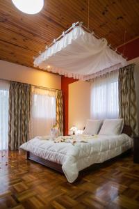 a large white bed in a room with windows at Andasibe Lemurs Lodge in Andasibe
