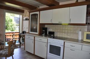 uma cozinha com electrodomésticos brancos, uma mesa e uma janela em Zum Landidyll em Lugau