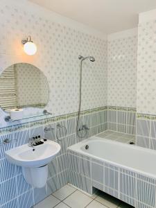 a bathroom with a tub and a sink and a bath tub at Azalia in Ustronie Morskie