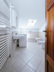 a white bathroom with two toilets and a sink at Casa GINESTRA a Bagno Vignoni in Bagno Vignoni